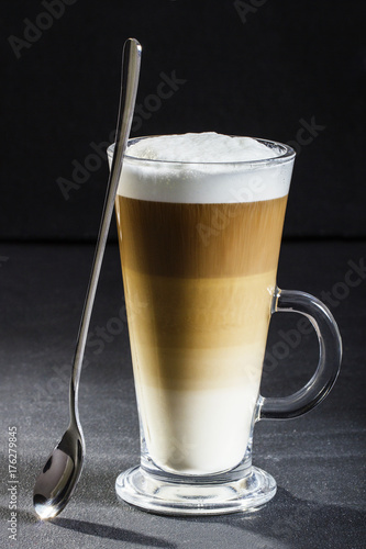 Ideal latte machiato coffee and spoon on a dark background