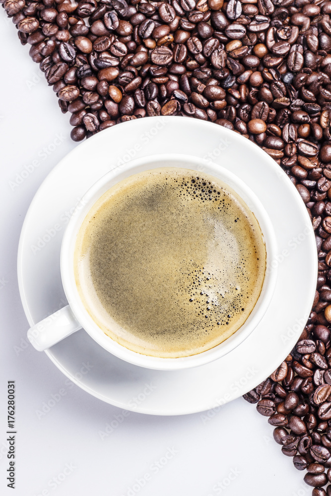 Coffee in a white cup on coffe beans and white background