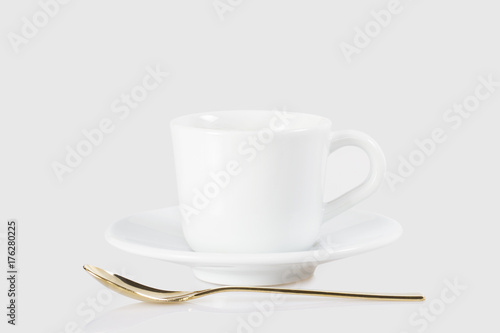 Espresso cup and golden spoon isolated on white