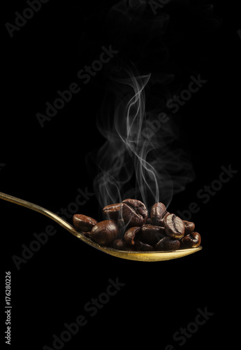 hot coffe beans on a golden spoon
