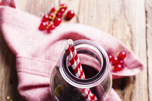 Red currant juice in a glass bottle closeup