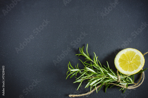 Rosemary and lemon on black with copyspace