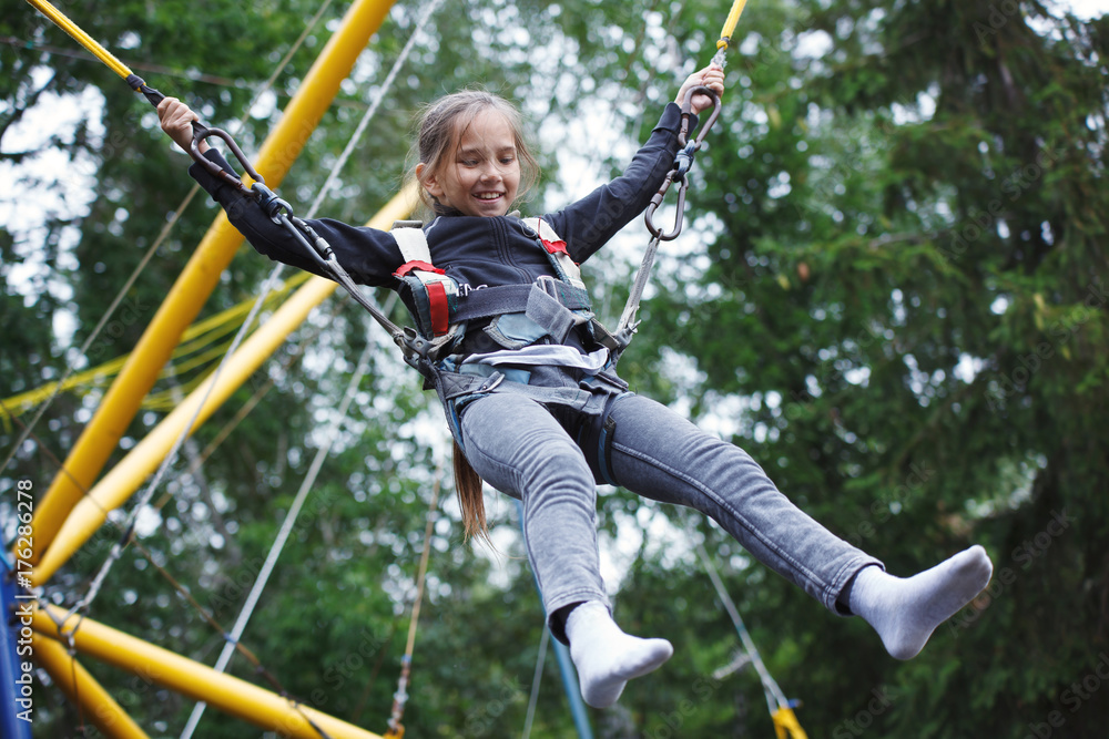 Young girl playing on bungee trampoline