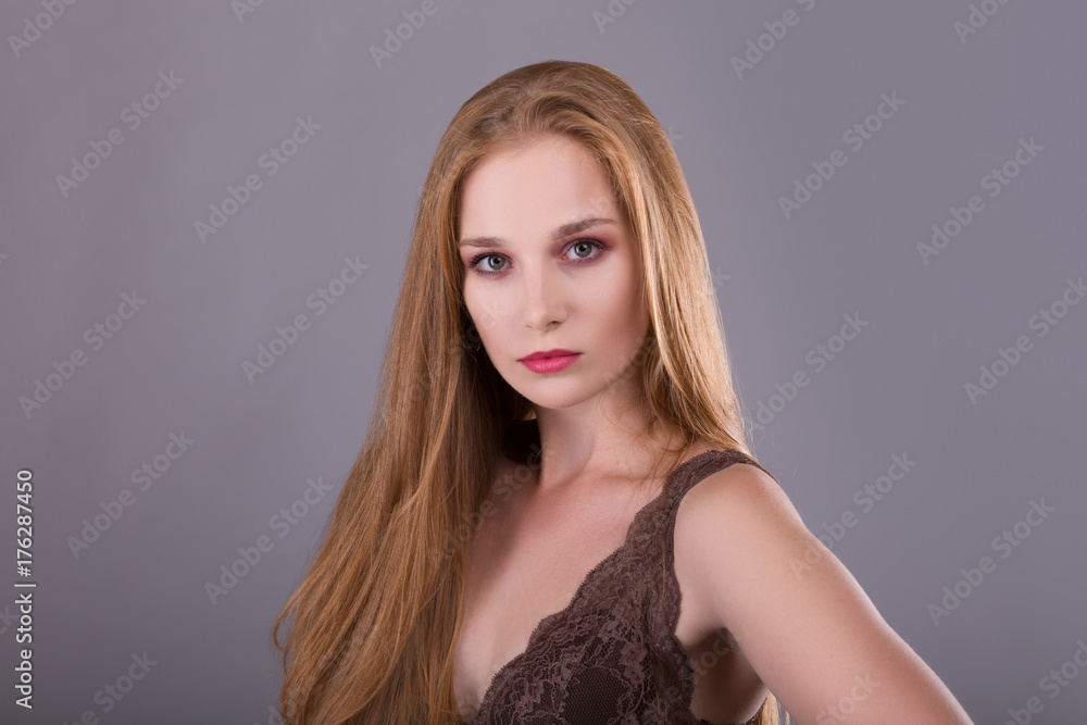 Redhead beautiful girl with long straight hair. Closeup portrait on gray background Redhead beautiful girl with long straight hair. Closeup portrait on gray background