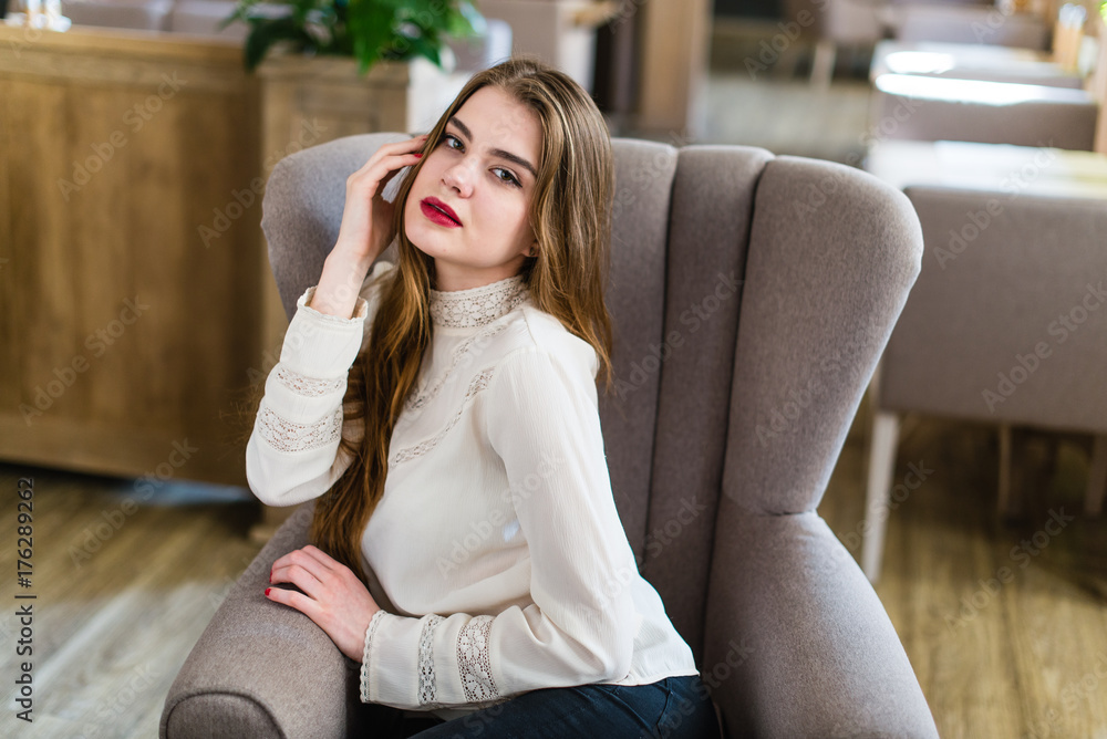 Beautiful young girl with professional makeup and hairstyle sitting in restaurant. Beautiful young girl with professional makeup and hairstyle sitting in restaurant.