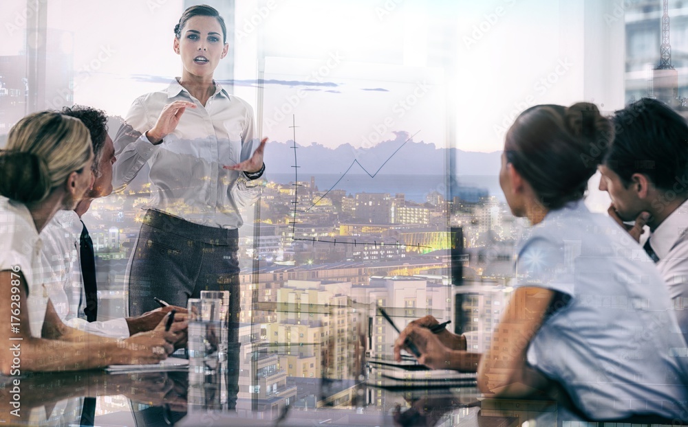 Businesswoman giving explication in front of a growing chart Businesswoman giving explication in front of a growing chart