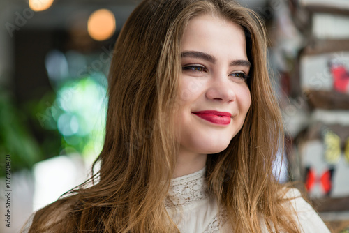 Portrait of beautiful young girl with professional makeup and hairstyle in restaurant.