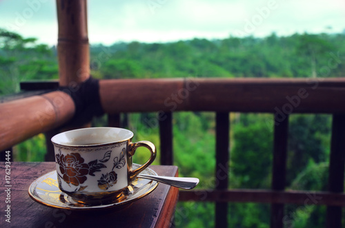 Cup of coffee with coffee plantation and jungle in background, Ubud, Bali