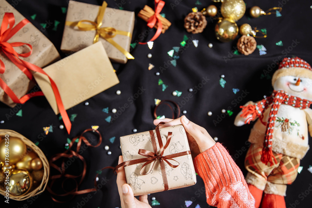 Fototapeta premium Hands of woman decorating Christmas gifts and decorations