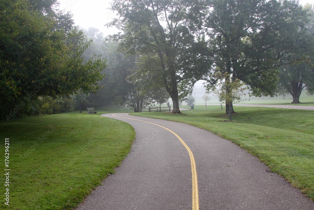 The winding pathway in the park on a foggy morning. The winding pathway in the park on a foggy morning.