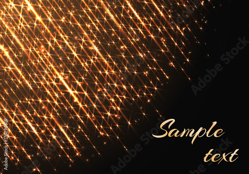The golden rays of light shine against a dark background. Festive decoration for the new year and Christmas.