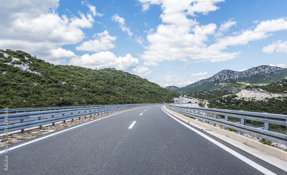 Naklejka premium High-speed country road among the mountains.