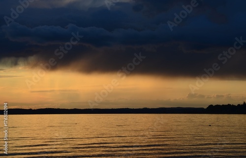 Bedrohlich schwarze Regenwolken   ber dem Chiemsee bei Sonnenuntergang