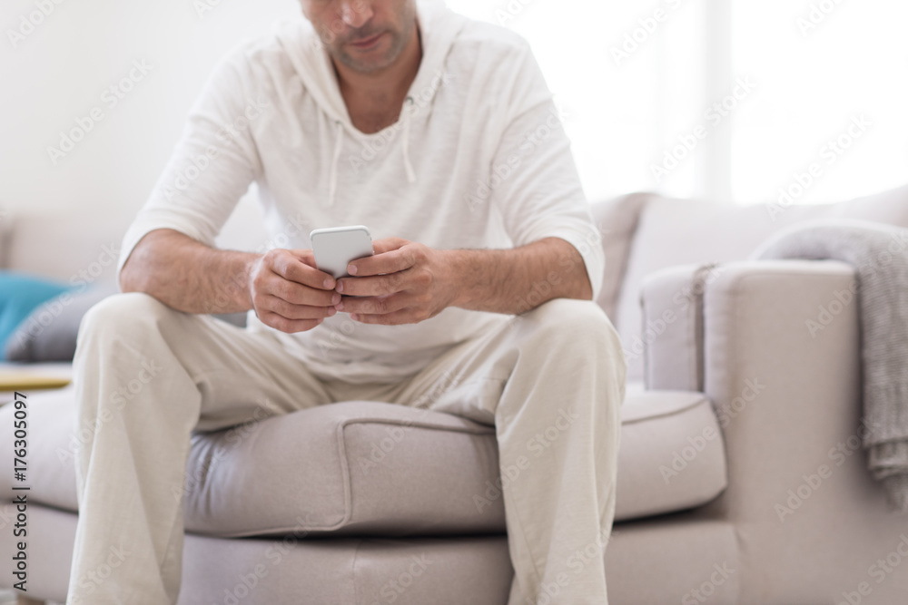 young man using a mobile phone at home young man using a mobile phone at home