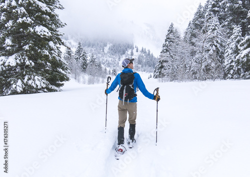 Man Snowshoeing Through a Winter Scene photo