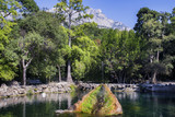 Lake in the park, decorative fountain and mountain.