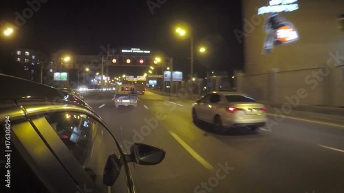 The car quickly changes from left to right lane in the city on the highway at night.