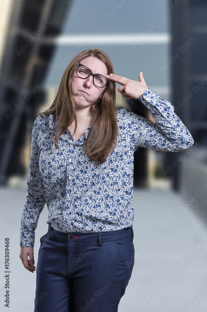 Pretty business woman making suicide gesture over blur background