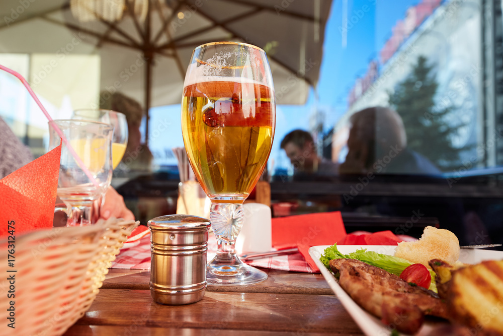 Glass of beer and street food on a cafe table. Glass of beer and street food on a cafe table.