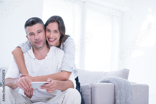 happy couple using mobile phone at home