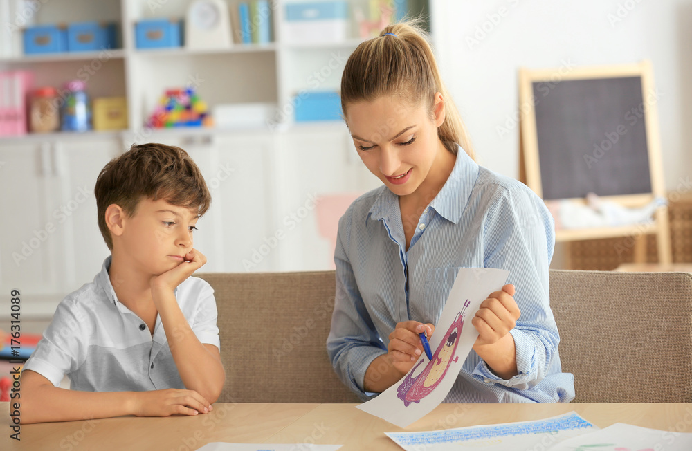 Young psychologist working with cute boy in office Young psychologist working with cute boy in office