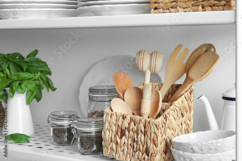 Kitchenware on shelf of storage stand