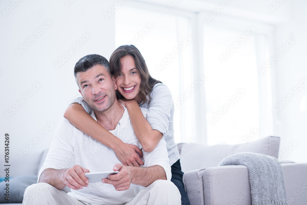 happy couple using mobile phone at home happy couple using mobile phone at home