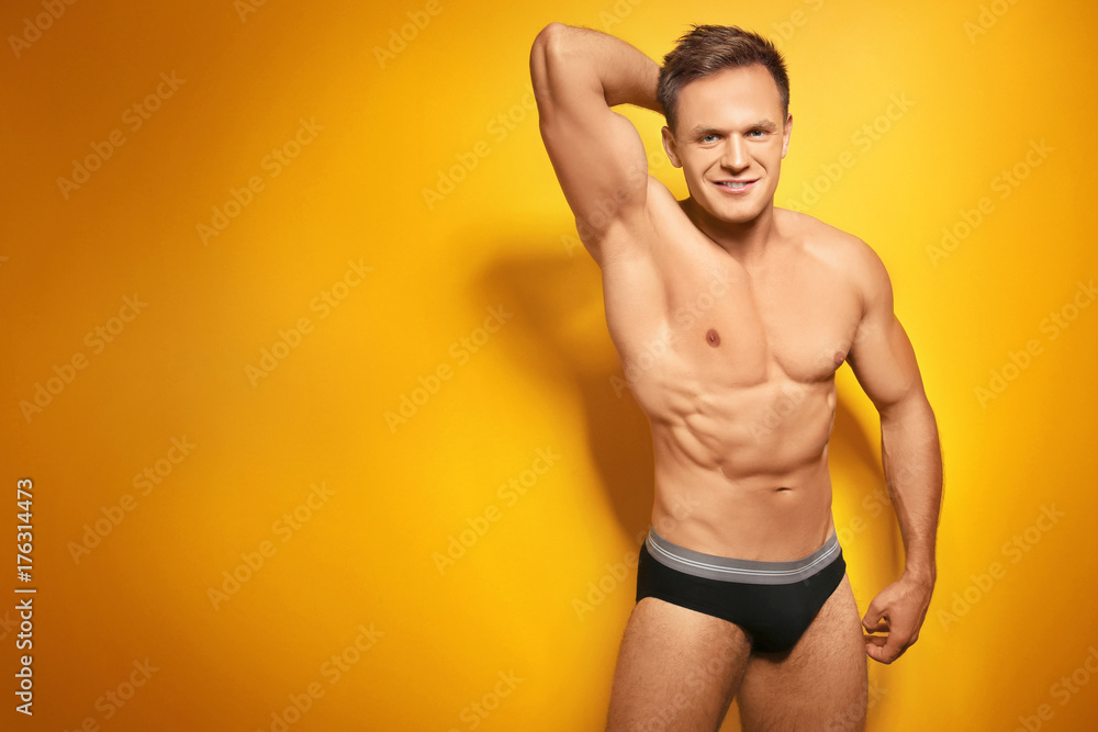 Fototapeta premium Muscular man in underwear on color background