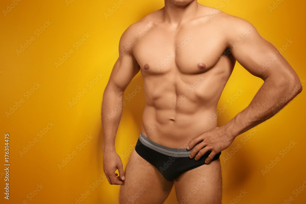 Muscular man in underwear on color background