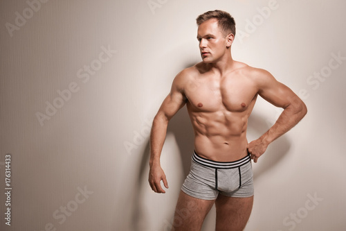 Muscular man in underwear on light background
