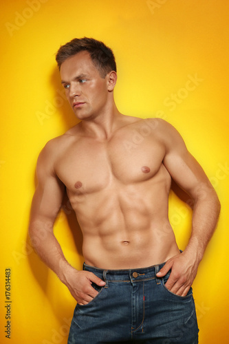Muscular man on color background