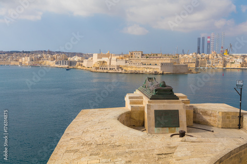 World War II Memorial, Bronze soldier lying on a catafalque overlooking the Grand Harbor and Fort St. Angelo, Valletta, Malta photo