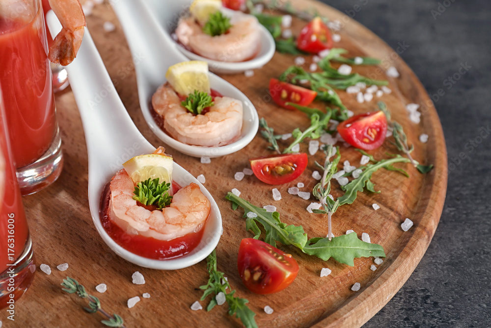 Board with spoons of tomato sauce and shrimps on table, closeup