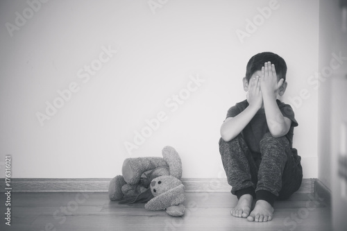 Little sad boy sitting on f...