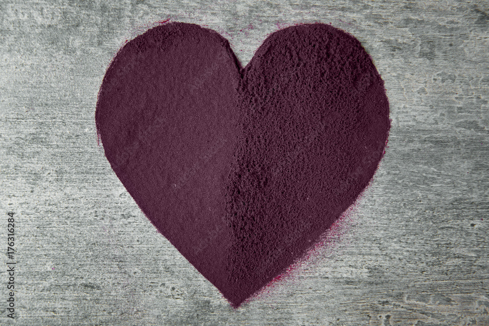 Heart made from acai powder on grey background Heart made from acai powder on grey background