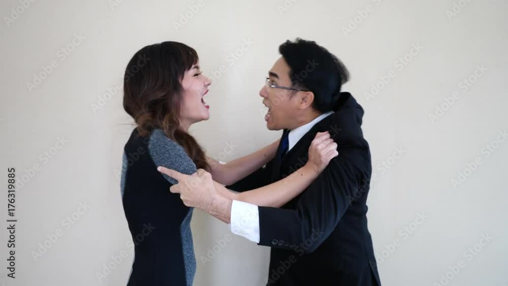 Two business people fighting in office hitting each other Two business people fighting in office hitting each other