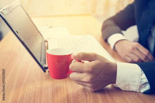 Businessman using laptop and drink coffee in the office