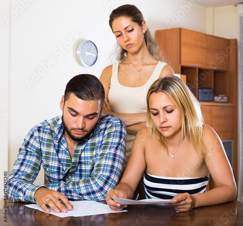 Three adults with papers.
