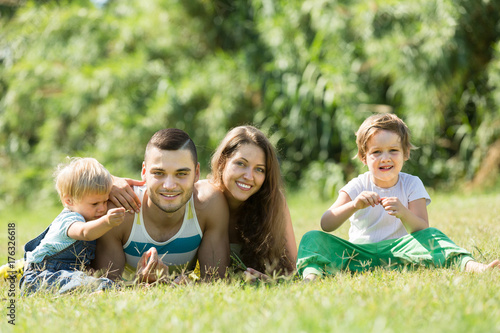 Family of four in grass at park © JackF