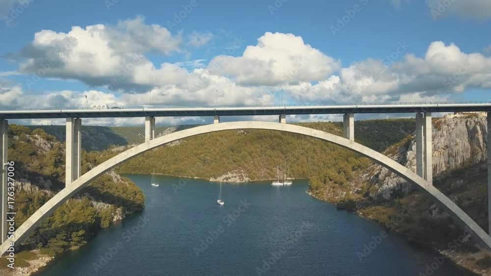 Aerial panorama view with bridge and sea around islands. Beautiful landscape surrounded with blue sea with bridge between. Autostrada bridge with traffic over Krka river at sunny day in Croatia. Aerial panorama view with bridge and sea around islands. Beautiful landscape surrounded with blue sea with bridge between. Autostrada bridge with traffic over Krka river at sunny day in Croatia.