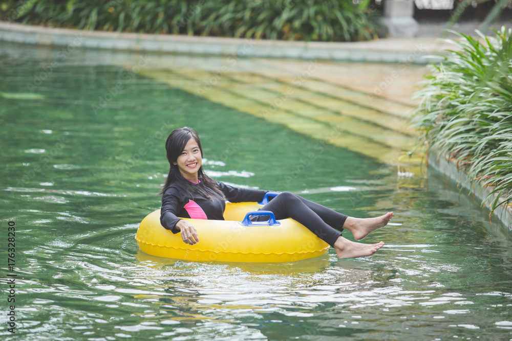 attractive asian woman relaxing at river pool