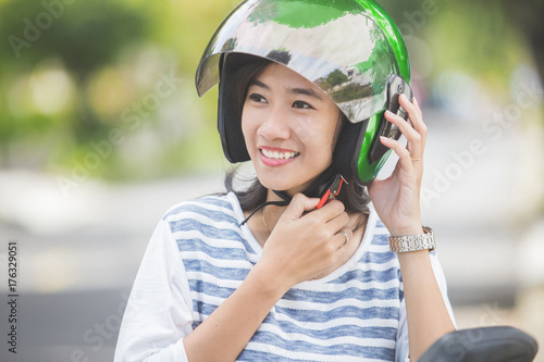 woman fastening her motorbike helmet