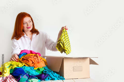 A woman is busy with the clutter in her wardrobe.