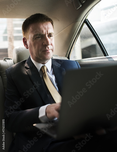 Businessman inside a car working on his laptop © Rawpixel.com