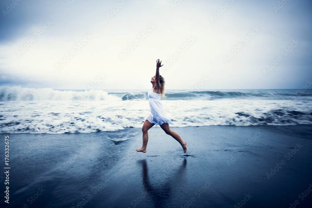 Happy woman running on the beach - obrazy, fototapety, plakaty 