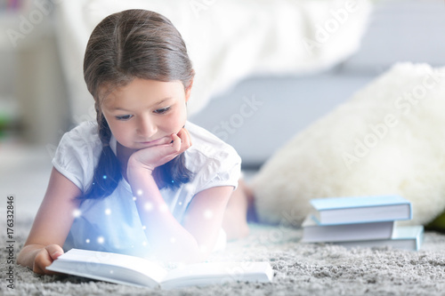 Cute little girl reading bo...