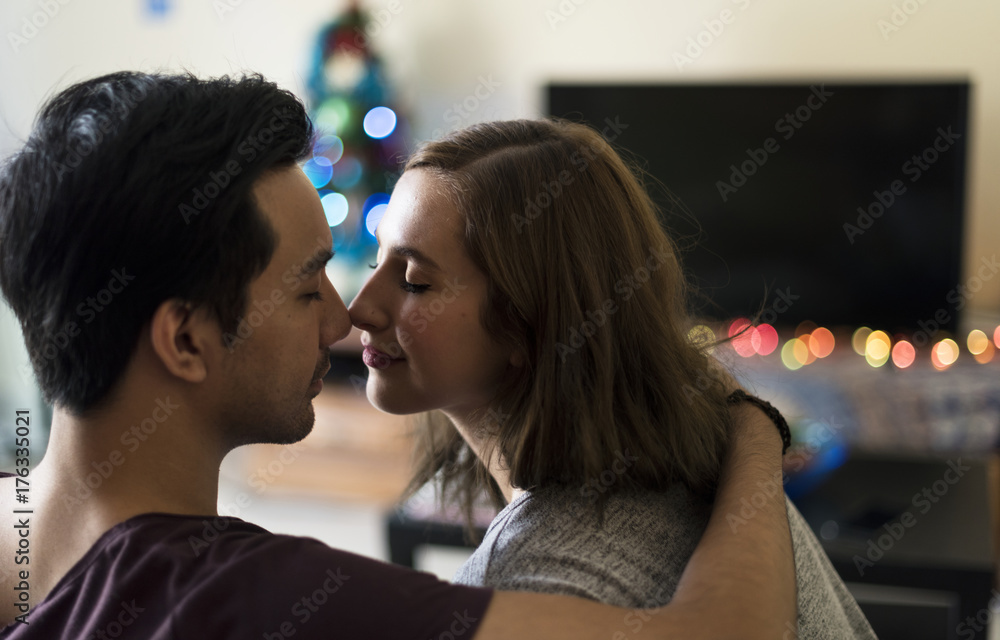 Naklejka premium Couple kissing in the sofa at home
