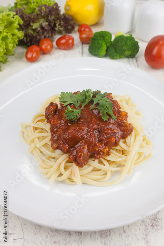 Pasta, macaroni and tomato sauce on a white dish are delicious. Put on a white wooden table.