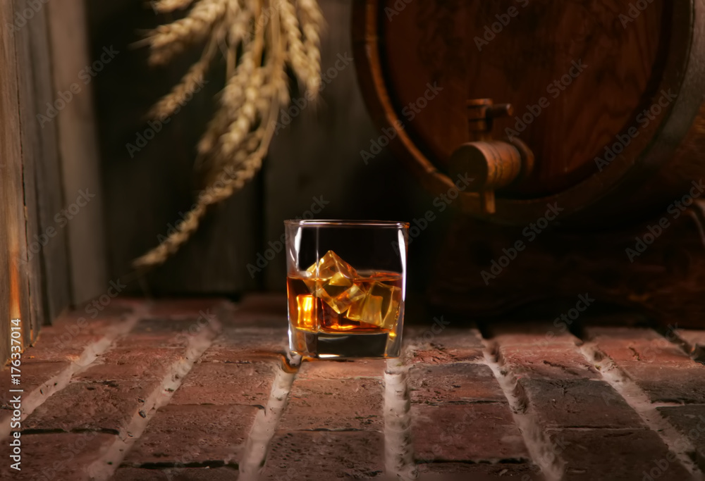 Glass of whiskey and wooden barrel in cozy cellar - obrazy, fototapety, plakaty 