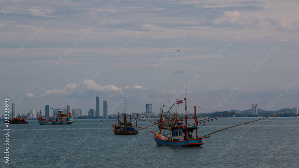 Fishing boats in the sea with the city background  in Pattaya district,Chonburi province ,Thailand.